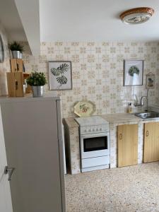 a kitchen with a white stove and a refrigerator at Las tres Luces Casa 2 in Picones