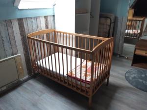 a wooden crib sitting in a room at gîte le voyageur in Tours-en-Vimeu