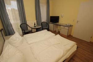 1 dormitorio con 1 cama blanca, mesa y sillas en F-1010 Strandhaus Mönchgut Bed&Breakfast DZ 23 Terrasse, strandnah, inkl Frühstück, en Lobbe