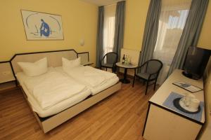 ein Schlafzimmer mit einem Bett und einem Tisch und Stühlen in der Unterkunft F-1010 Strandhaus Mönchgut Bed&Breakfast DZ 23 Terrasse, strandnah, inkl Frühstück in Lobbe