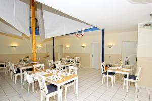 un restaurante con mesas, sillas blancas y registrador en F-1010 Strandhaus Mönchgut Bed&Breakfast DZ 23 Terrasse, strandnah, inkl Frühstück, en Lobbe