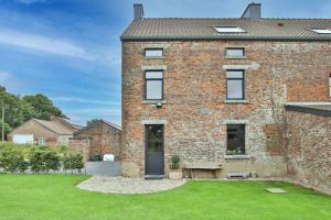 a brick house with a lawn in front of it at La Cense de Baudecet - Le Corps de Logis in Gembloux