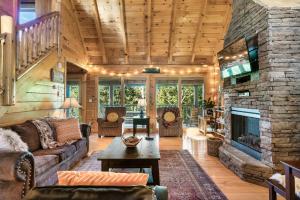 uma sala de estar com uma grande lareira de pedra em Lux Spa Cabin, Sauna, HotTub, Indoor Pool, Mins to PF em Sevierville