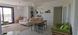 kuchnia i salon ze stołem i zielonymi krzesłami w obiekcie Venezia nature&beach w Cavallino-Treporti