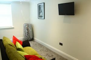 a living room with a yellow couch and a flat screen tv at The Ship Leopard Hotel - No Children in Portsmouth