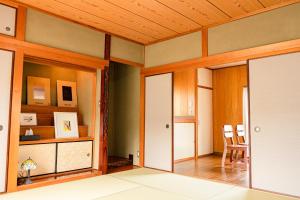 um quarto com portas de correr e uma mesa e cadeiras em とまばりゲストハウス em Sanuki