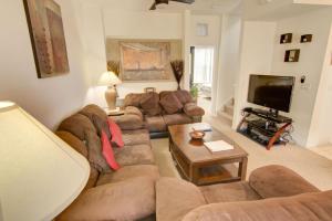 ein Wohnzimmer mit Sofa und Fernseher in der Unterkunft Magical Fiesta Key Townhouse in Kissimmee