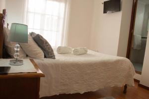 a bedroom with a bed with a lamp and a mirror at Gouveia Residence in Coimbra