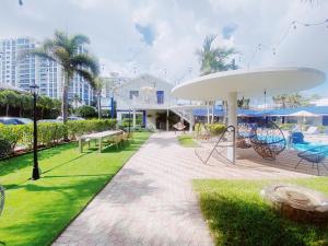 a patio with a table and chairs in a park at Sea Steps By Lowkl in Pompano Beach