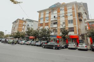 een stadsstraat met auto's geparkeerd voor gebouwen bij Grace's Centre Apartment in Shkodër