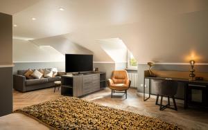 um quarto com uma cama, uma televisão e um sofá em Maison Viktoria Augsburg em Augsburg