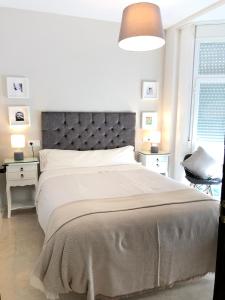 a bedroom with a large bed with a gray headboard at Casa El Campanario in El Bosque