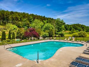 uma piscina com água azul num quintal em Lux Spa Cabin, Sauna, HotTub, Indoor Pool, Mins to PF em Sevierville