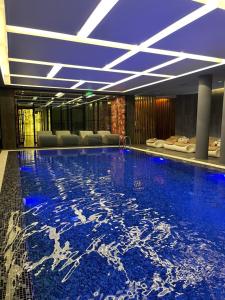 a hotel lobby with a swimming pool with blue lighting at Klajdi Resort & SPA in Golem