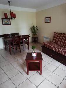 un salon avec un canapé et une table dans l'établissement Appart-dans Résidence de vacances au coeur du Golf-Le domaine de Gascogne, à Biscarrosse 8 autres photos