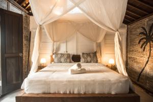 a bedroom with a canopy bed with a statue on it at Tropical Canggu Hostel in Canggu +60 photos