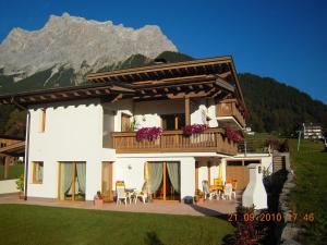 Una casa con balcón con una montaña al fondo. en Haus Angelika, en Ehrwald