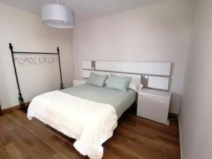 a bedroom with a white bed with a white blanket at A casa dos retales in Cangas de Morrazo