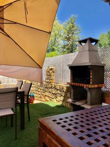um forno de pizza sentado em cima de uma mesa com um guarda-chuva em Casa El Campanario em El Bosque