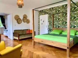 Boutique Apartment Villa Landenberger Outlet Metzingen P12E في ميتزينغين: غرفة نوم مع سرير المظلة مع الوسائد الخضراء