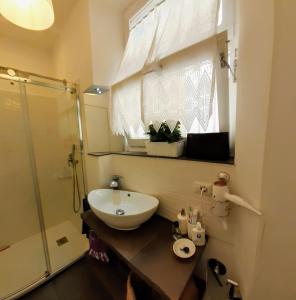 a bathroom with a sink and a glass shower at Il Balcone Sul Corso in Ancona