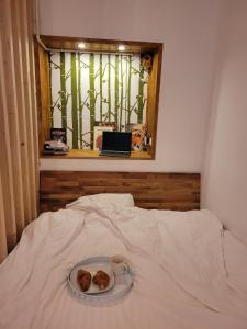 een bord met twee donuts op een bed met een raam bij Bubbles studio Sinaia with terrace in Sinaia