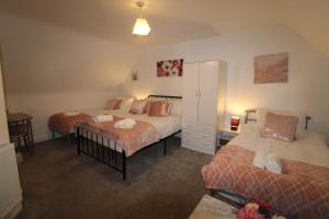 a bedroom with two beds and a mirror at Pavement House in Sutton in Ashfield