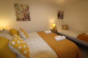 a bedroom with two beds with towels on them at Pavement House in Sutton in Ashfield