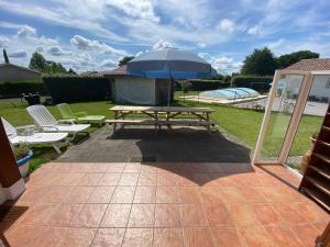 a picnic table with an umbrella on a patio at Maison familiale in Soorts-Hossegor