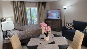 a living room with a bed and a table with flowers on it at Beach Front Condo Paradise. Ground Floor.Studio. in Longboat Key