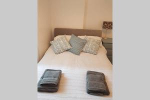 een bed met twee handdoeken en kussens erop bij St Ives self catering apartment private parking near beaches in St Ives