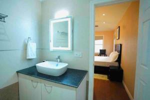 a bathroom with a sink and a bedroom with a bed at Le Reve Valley - Canadian cottage 2 - 3BHK Luxury cottage,Bonfire,Barbeque,Gym,Kids play zone,Lake view in Bhīm Tāl +41 photos