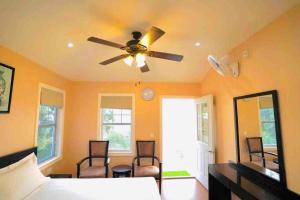 a bedroom with a bed and a ceiling fan at Le Reve Valley - Canadian cottage 2 - 3BHK Luxury cottage,Bonfire,Barbeque,Gym,Kids play zone,Lake view in Bhīm Tāl