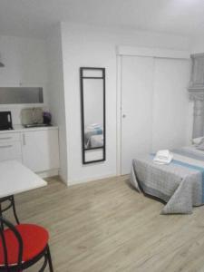 a bedroom with a bed and a table and a mirror at Moderno apartamento en el corazón de Madrid Sol in Madrid