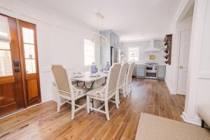 a white dining room with a table and chairs at Guesthouse Charleston EAST 42 A & B in Charleston +18 photos