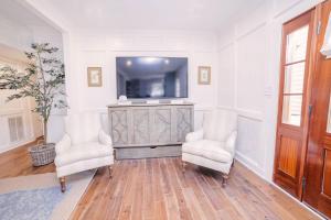 a living room with two chairs and a television at Guesthouse Charleston EAST 42 A & B in Charleston