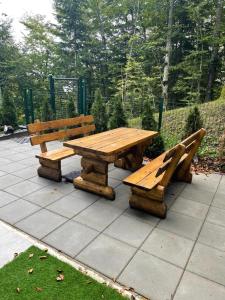 a wooden picnic table and benches on a patio at Bjelasnica White apartmani in Bjelašnica