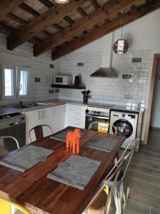 Casa Rural Maño في ديلتيبري: مطبخ مع طاولة خشبية مع كراسي حوله