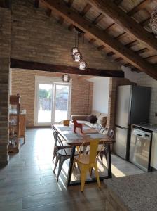 a kitchen and dining room with a table and refrigerator at Casa Rural Maño in Deltebre
