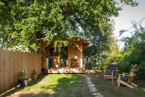 a backyard with a gazebo and two chairs at Joli chalet en bois à 7 mn des plages du Bassin d'Arcachon in Andernos-les-Bains