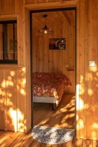a bedroom with a bed in a wooden cabin at Joli chalet en bois à 7 mn des plages du Bassin d'Arcachon in Andernos-les-Bains