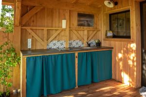 a kitchen with a blue counter in a cabin at Joli chalet en bois à 7 mn des plages du Bassin d'Arcachon in Andernos-les-Bains