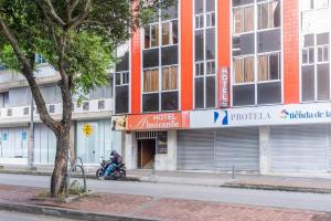 a man on a motorcycle parked in front of a building at Ayenda Almirante in Bucaramanga