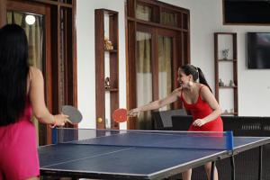 two women playing a game of table tennis at KILLA Casa Hospedaje in Iquitos
