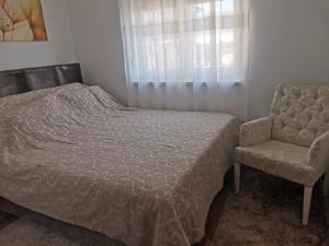 um quarto com uma cama e uma cadeira em Bellavista em Vrnjačka Banja