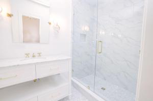 a white bathroom with a shower and a sink at Guesthouse Charleston EAST 42 B in Charleston