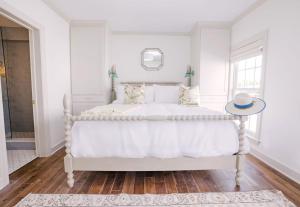 a white bedroom with a white bed and a window at Guesthouse Charleston EAST 42 B in Charleston
