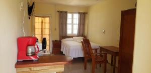 1 dormitorio con cama y mesa con cafetera en Pal's on the beach - Dangriga, Belize, en Dangriga