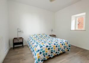 - une chambre avec un lit et une couette colorée dans l'établissement Maison chaleureuse, à Hermonville