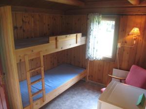 a bunk bed in a cabin with a window at Smegarden Camping in Oppdal